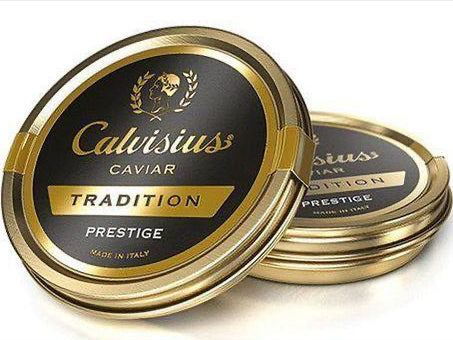 A tin can of Calvisius White Sturgeon Caviar with the brand's logo and the word 'CAVIAR' prominently displayed on the top. The can is gold-colored with a black background and text.